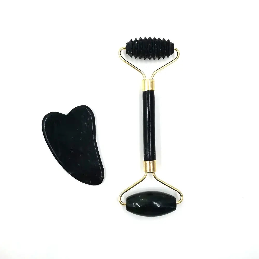 Facial massage roller with a black textured roller head and gold-accented handle, accompanied by a heart-shaped gua sha tool.