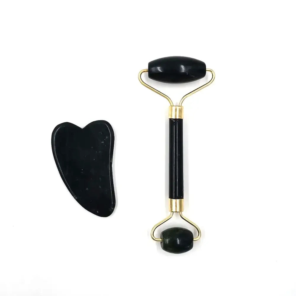 Facial massage roller with a black handle and gold-colored metal frame, accompanied by a heart-shaped gua sha tool.