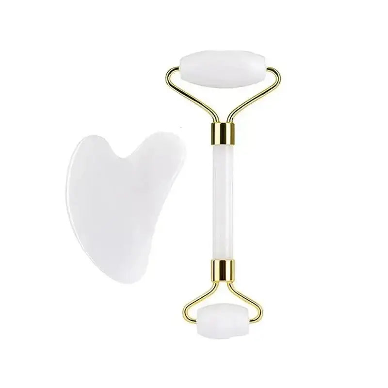 White and gold facial massage roller with dual ends.