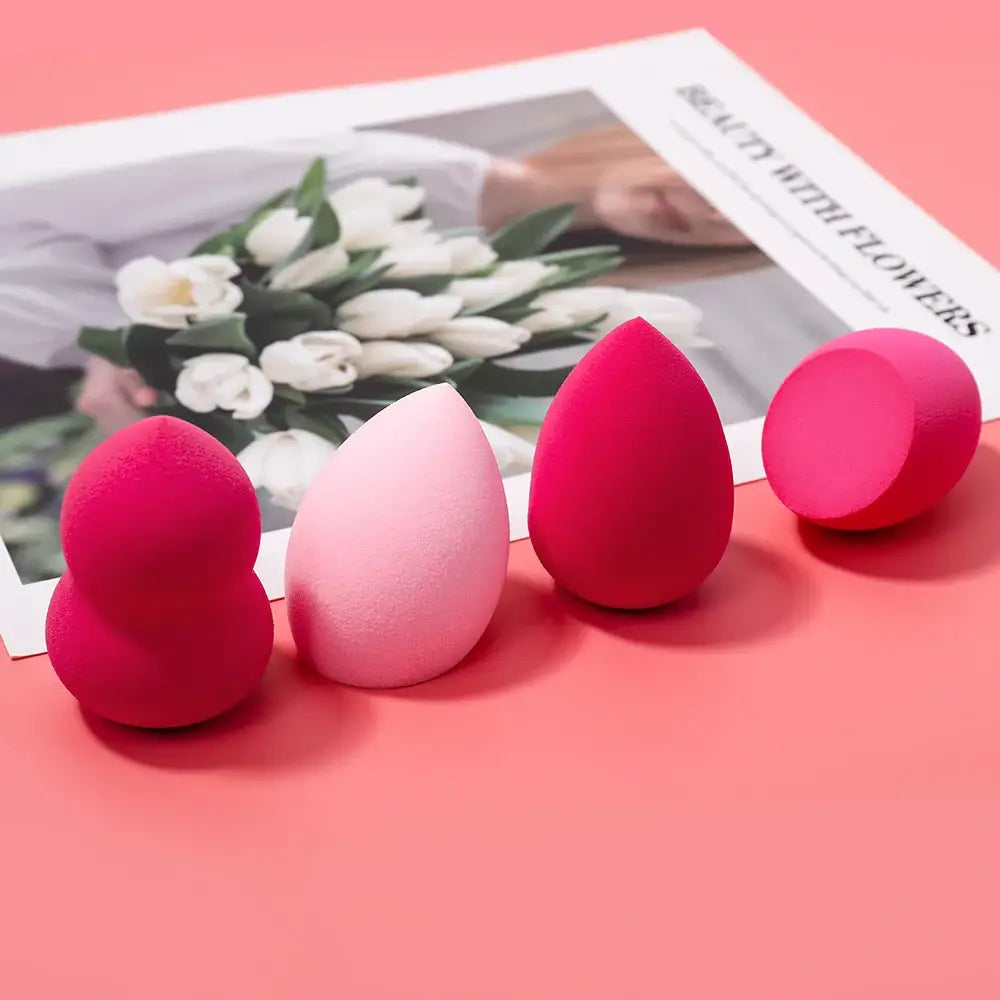 Makeup sponges or beauty blenders in various shades of pink and red.