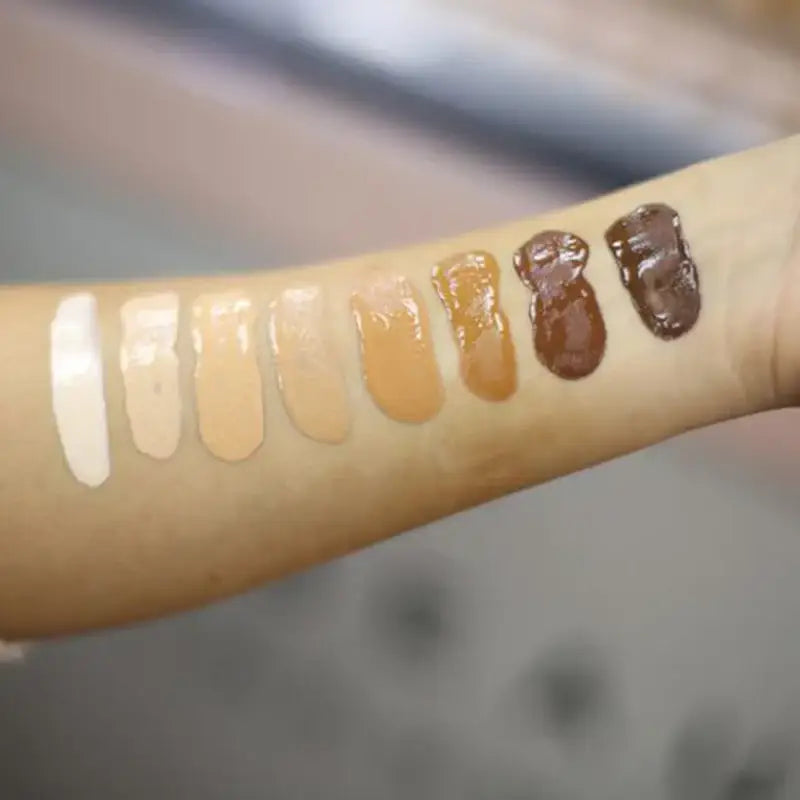 Swatches of various skin tone foundation shades on an arm.