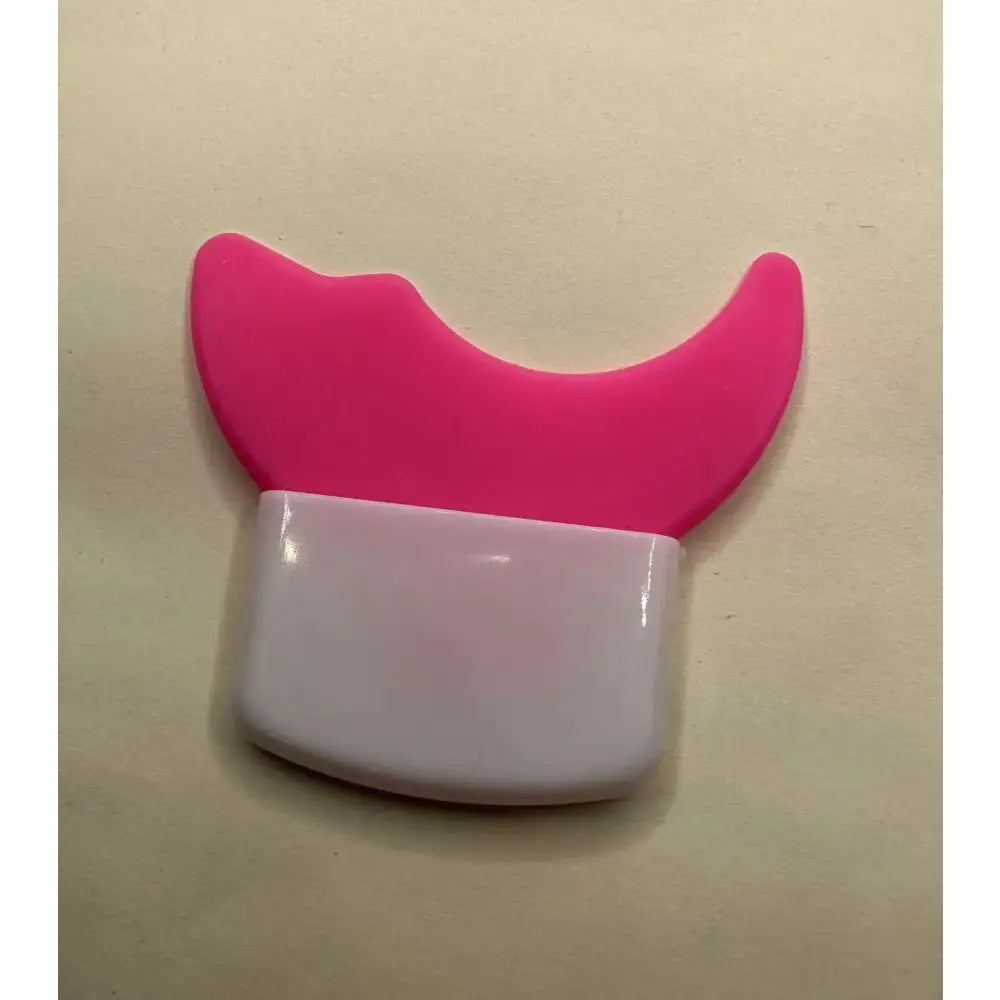 Pink and white plastic object shaped like a stylized cat head or horns.