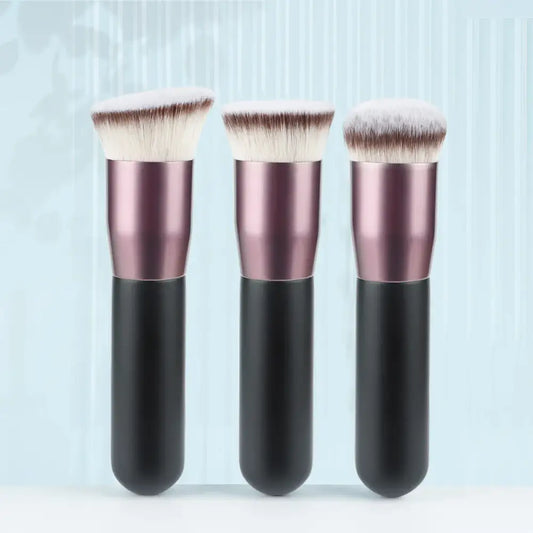 Three makeup brushes with metallic pink handles and black bases.