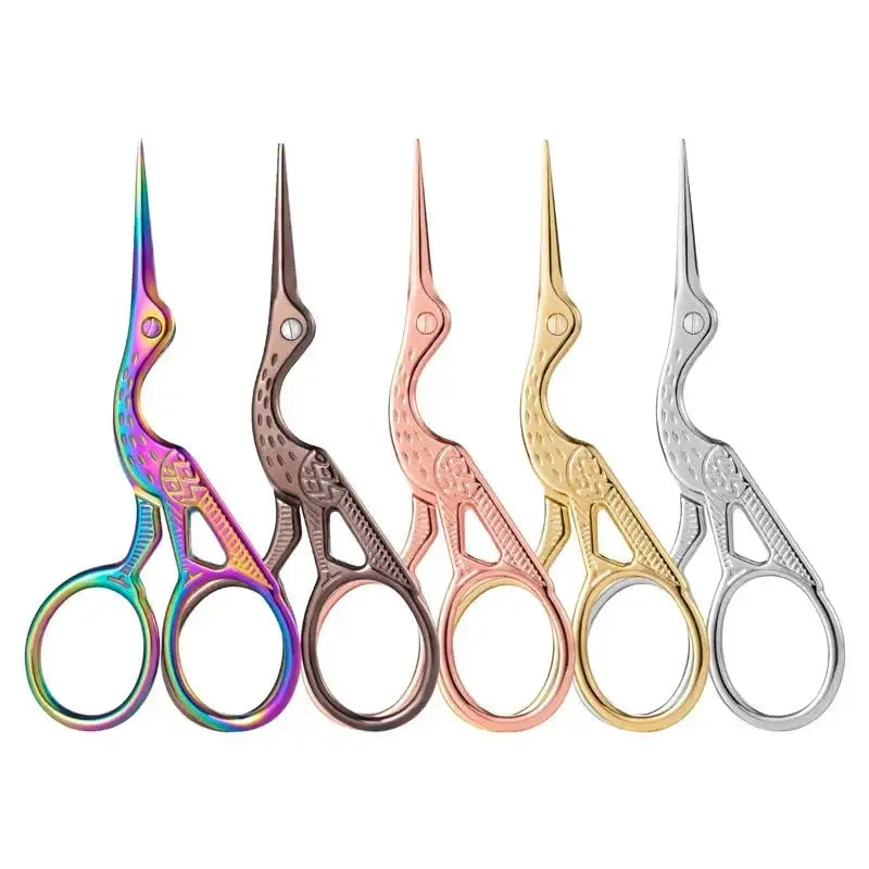 Five decorative stork-shaped scissors in different metallic colors arranged in a row.