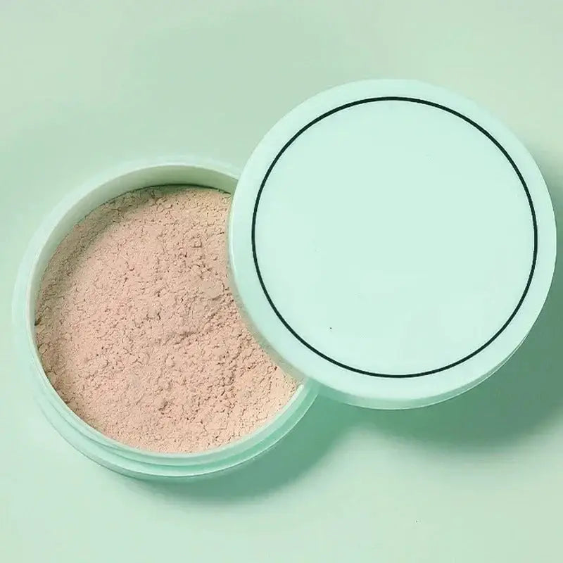 Circular container of loose face powder with an open lid.