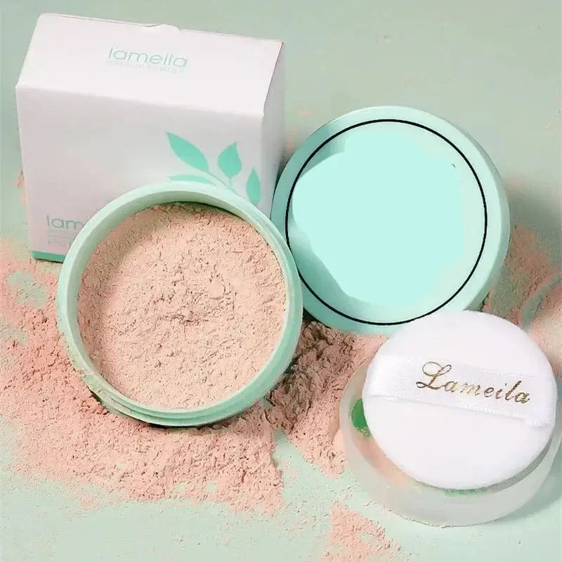 Loose face powder in a mint green compact with scattered powder around it.