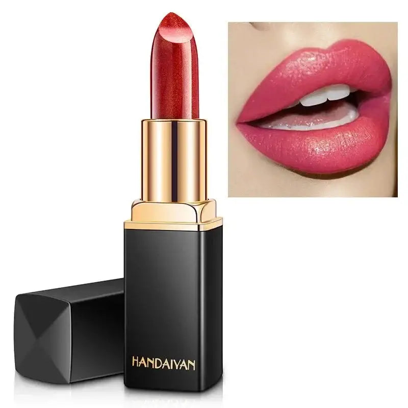 Lipstick in a black and gold tube with a red shade.