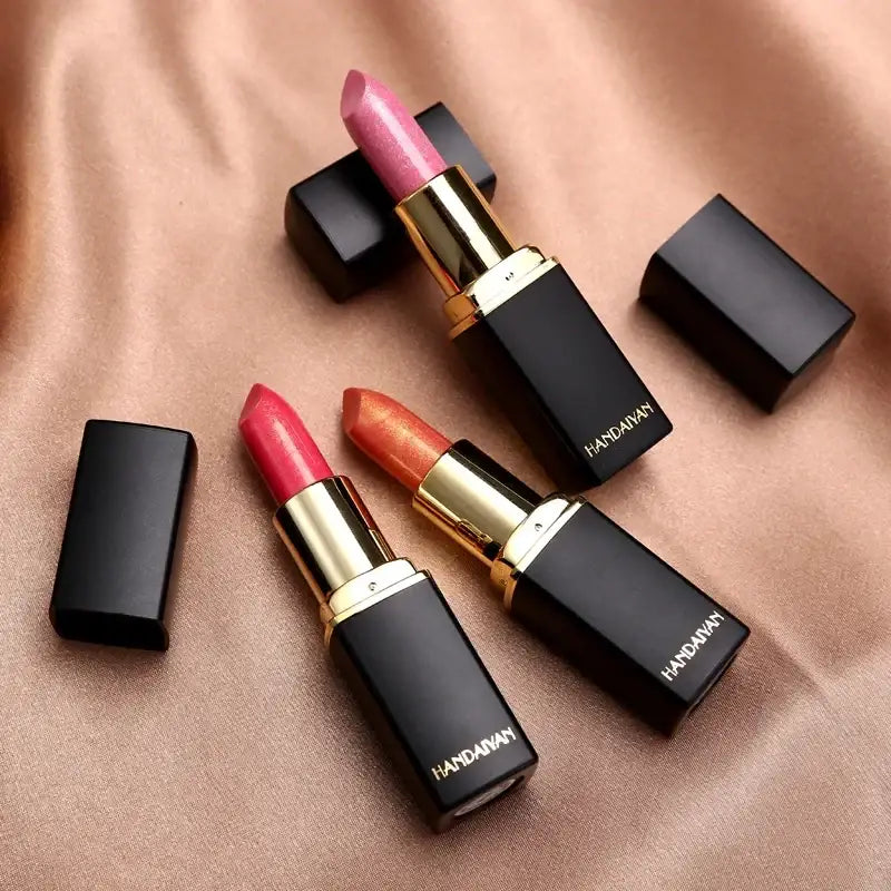 Luxury lipsticks in black cases with gold accents.