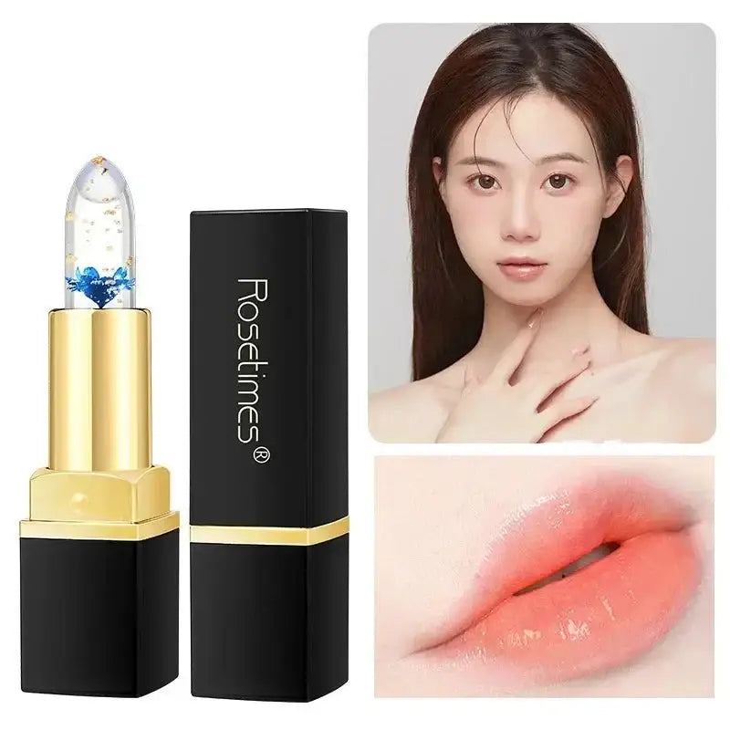 Gold and black lipstick tube with a clear cap containing a blue flower.