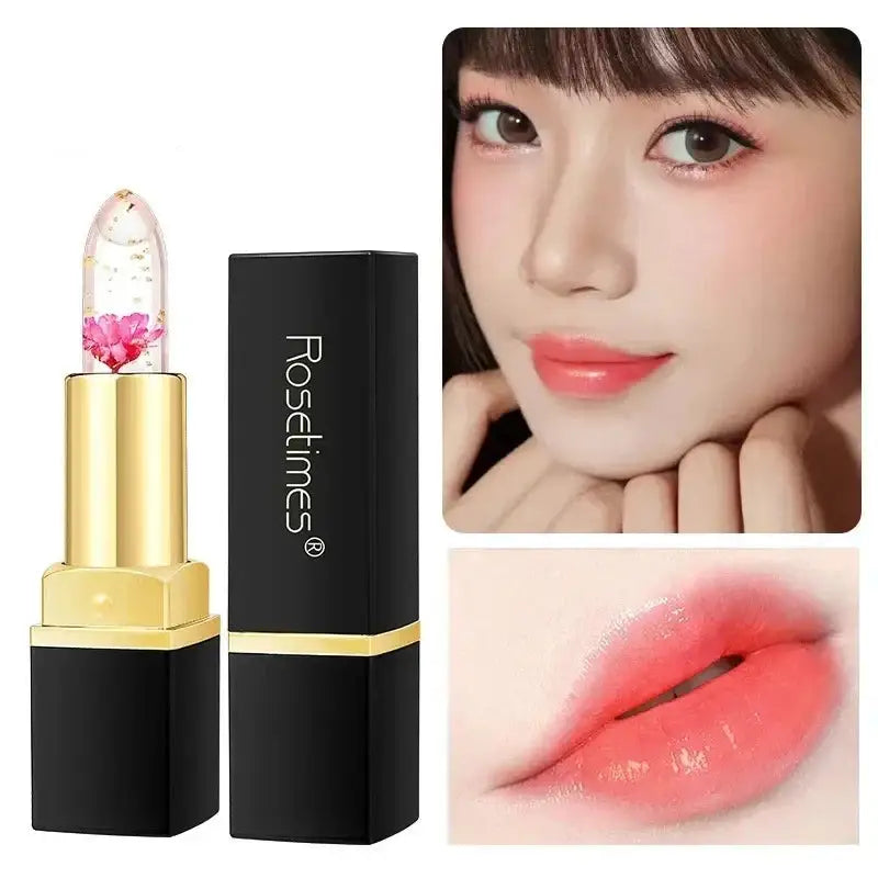 Gold and black lipstick tube containing a clear lipstick with a pink flower inside.