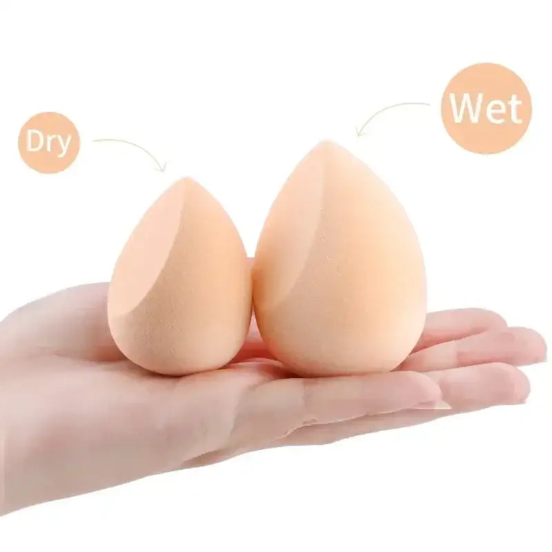 Two teardrop-shaped makeup sponges resting on an open palm.