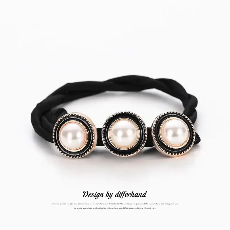 Black elastic hair tie adorned with three pearl-like beads in ornate silver settings.