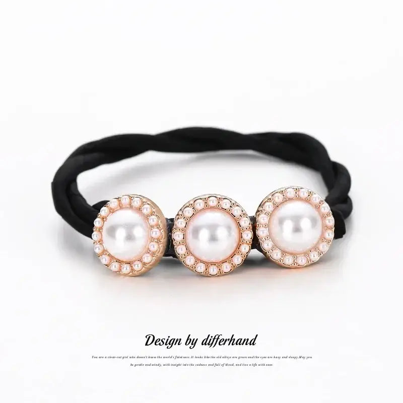 Elastic hair tie featuring three pearl-like beads surrounded by rhinestones.