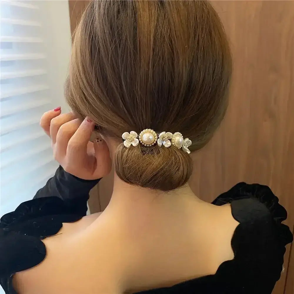 Elegant updo hairstyle adorned with delicate floral hair accessories.