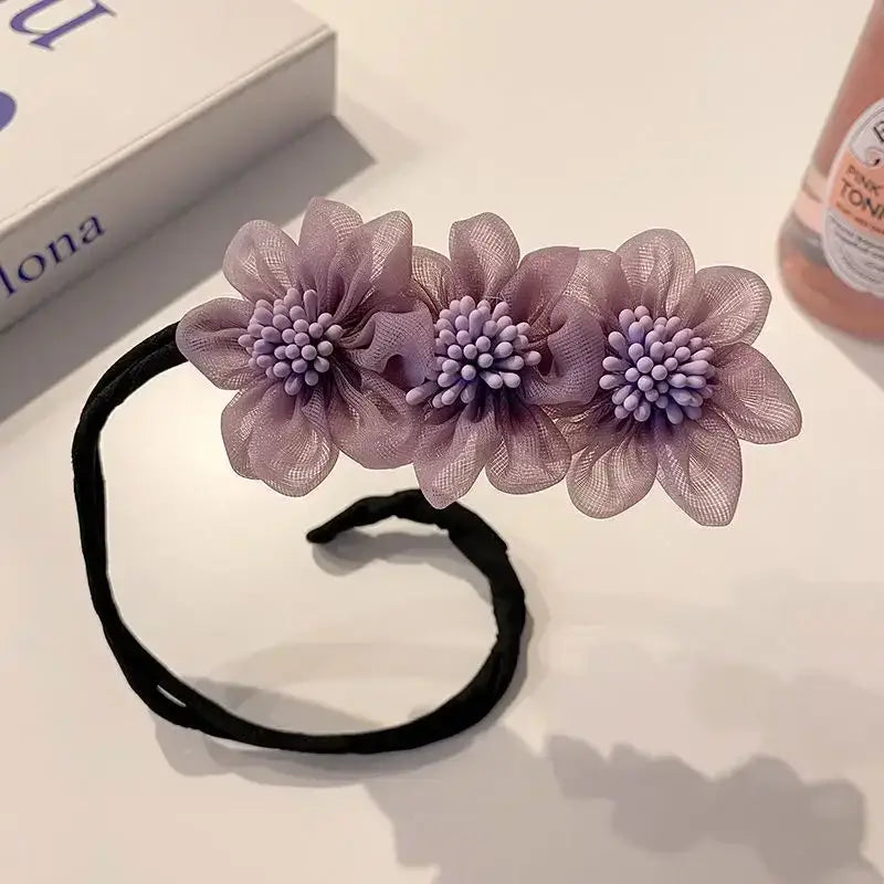 Hair tie adorned with three lavender fabric flowers.