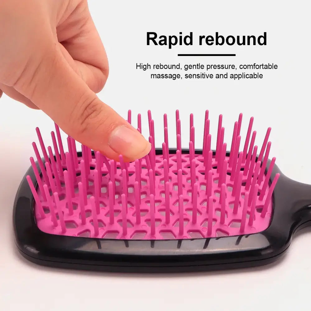 Pink-bristled hairbrush with flexible cushioned base for gentle scalp massage.