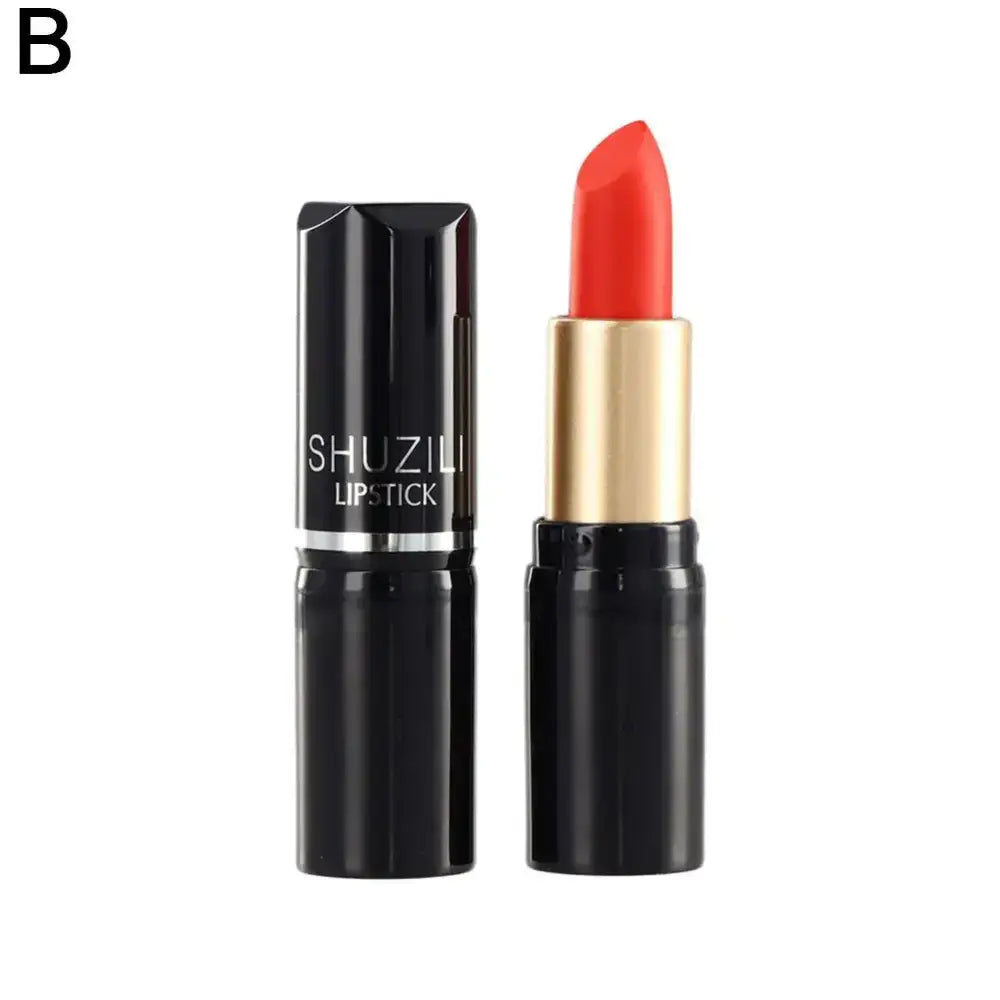 Bright coral-red lipstick in a black and gold tube.