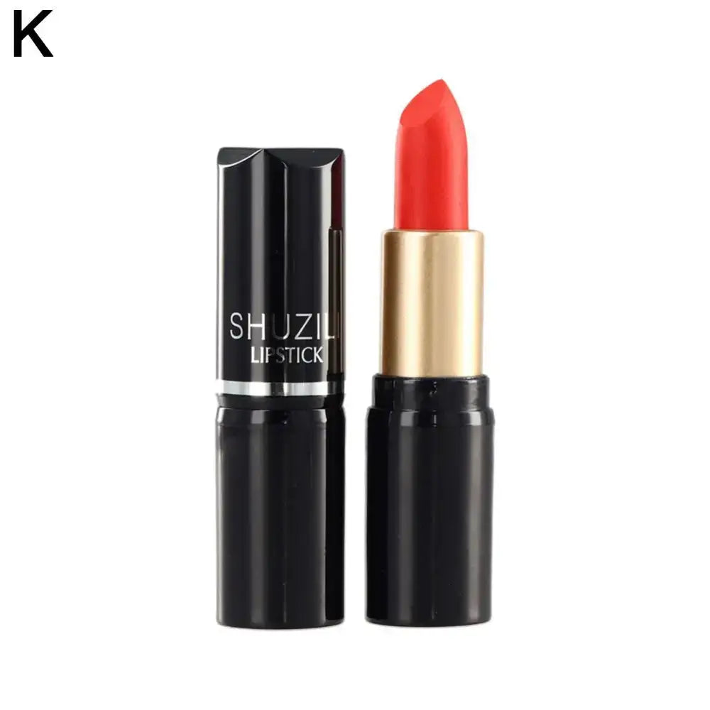 Bright coral-red lipstick in a black and gold tube.