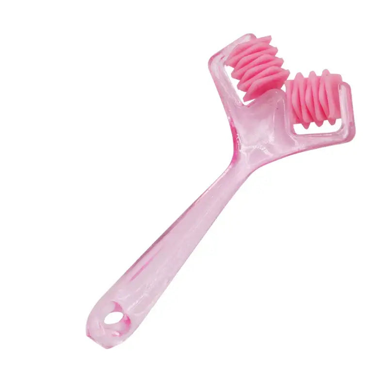 Pink plastic facial massage tool with rolling wheels.