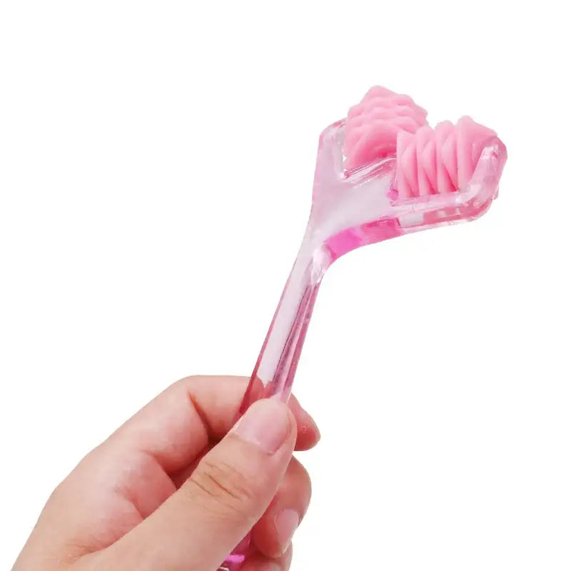 Pink plastic tongue scraper held by a hand.