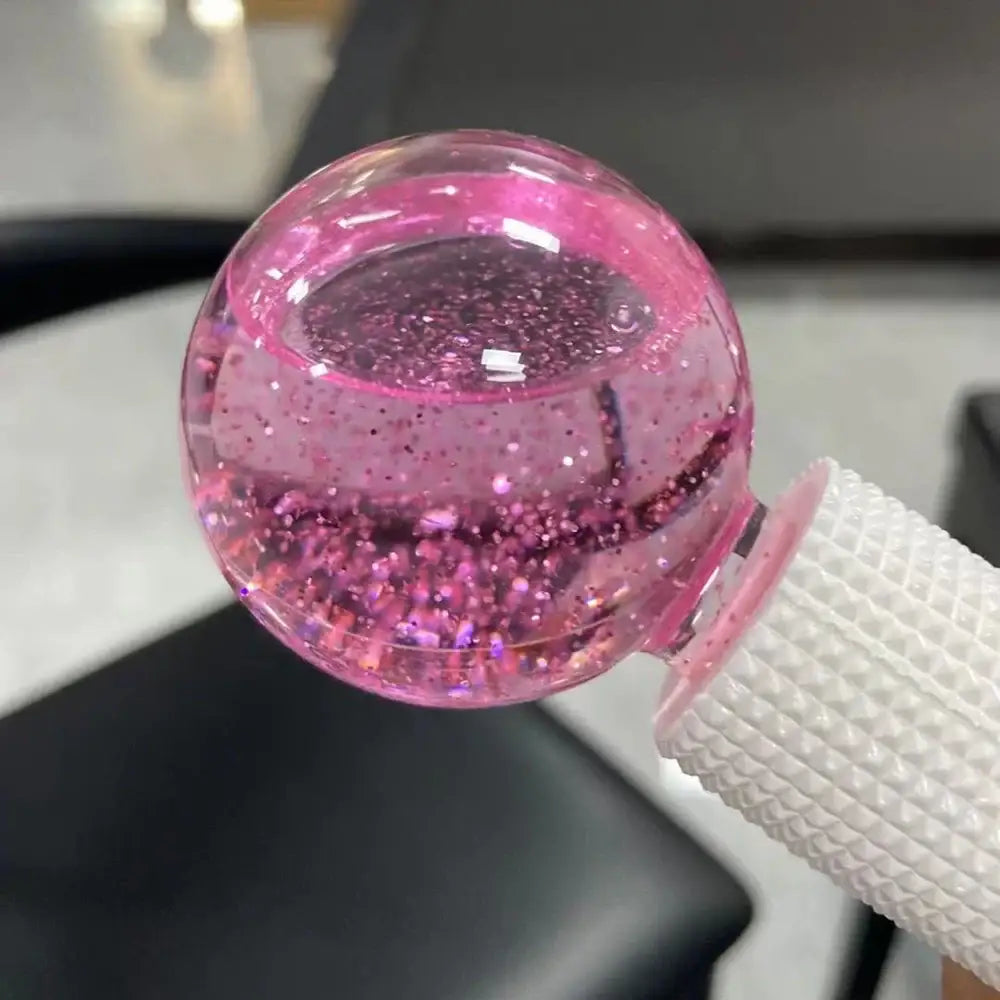 Pink glass sphere filled with glitter and attached to a white strap.