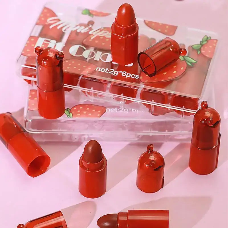 Red lipstick-shaped containers or packaging with strawberry decorations.