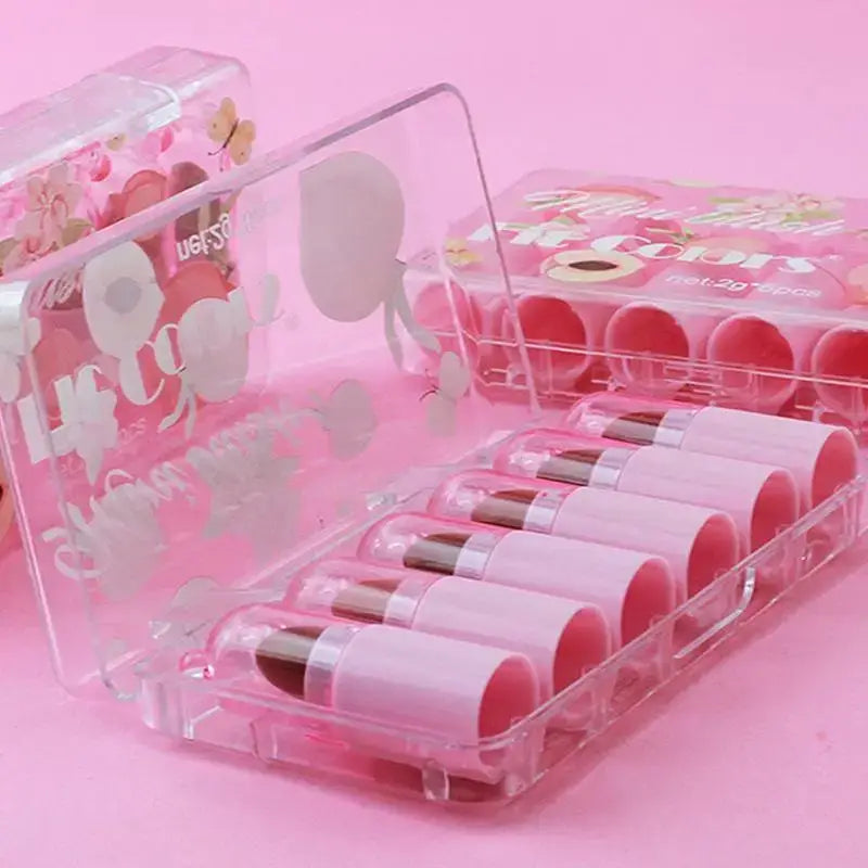 Set of pink lipsticks in clear plastic cases with heart designs.