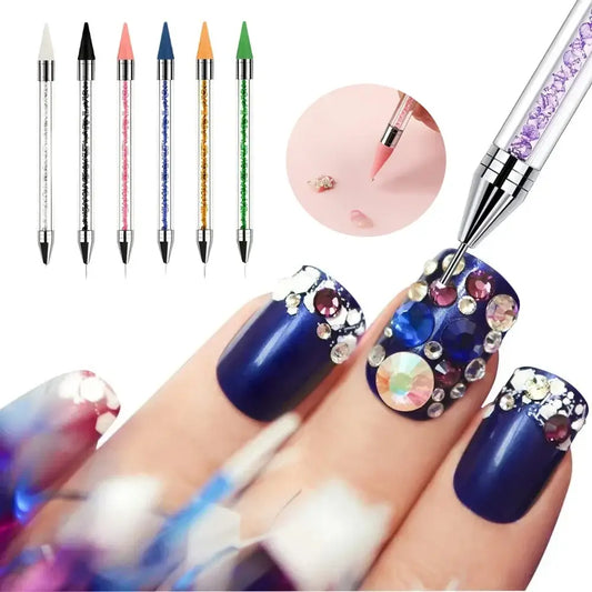 Decorated fingernails with blue polish and colorful embellishments alongside nail art tools.