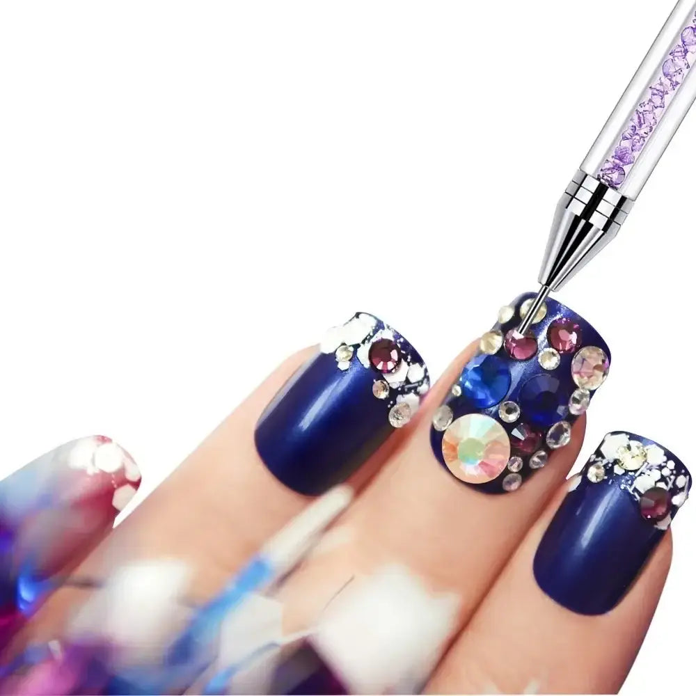 Elaborately decorated fingernails with dark blue polish and colorful gemstone embellishments.