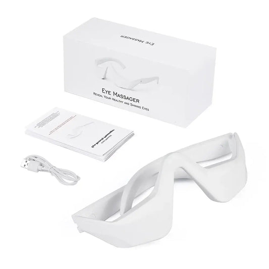 Eye massager device with a sleek white design and accompanying accessories.