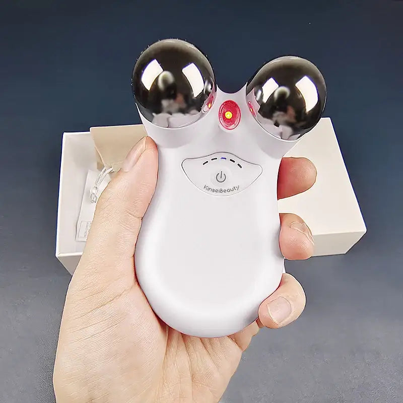 Handheld electronic device with two metallic spheres and a red light, resembling a mouse-like shape.