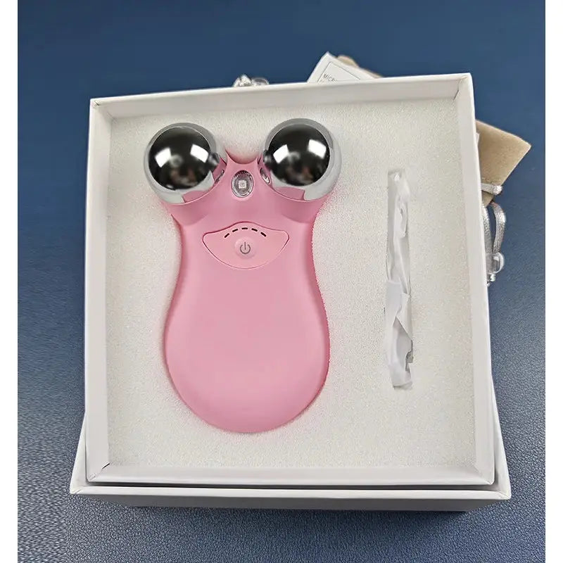 Pink facial massage tool with two metal spheres for eyes.