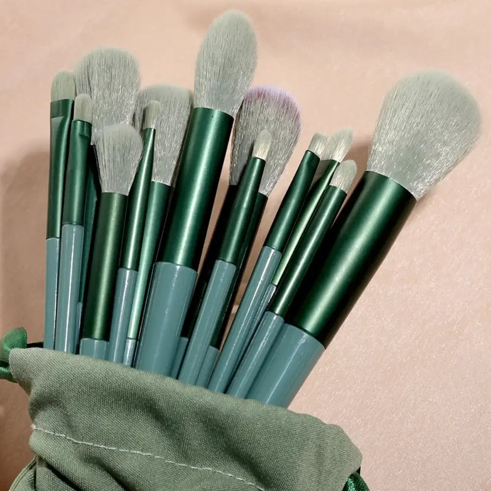 Set of makeup brushes with green handles and soft bristles.