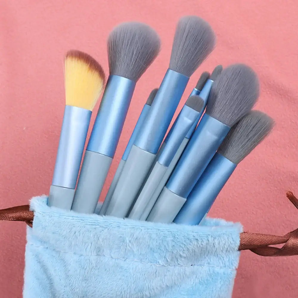 Set of makeup brushes with blue handles in a light blue holder.