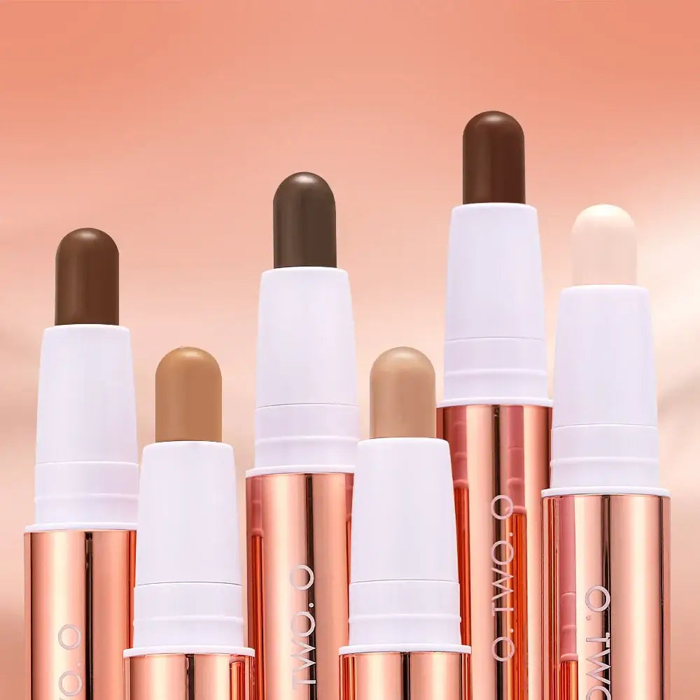 Collection of makeup foundation or concealer sticks in various shades.