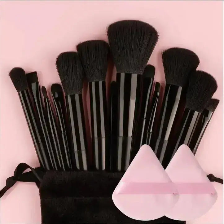 Set of black makeup brushes with various sizes and shapes.