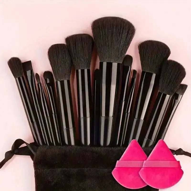 Set of makeup brushes with black bristles and handles, accompanied by pink silicone makeup applicators.