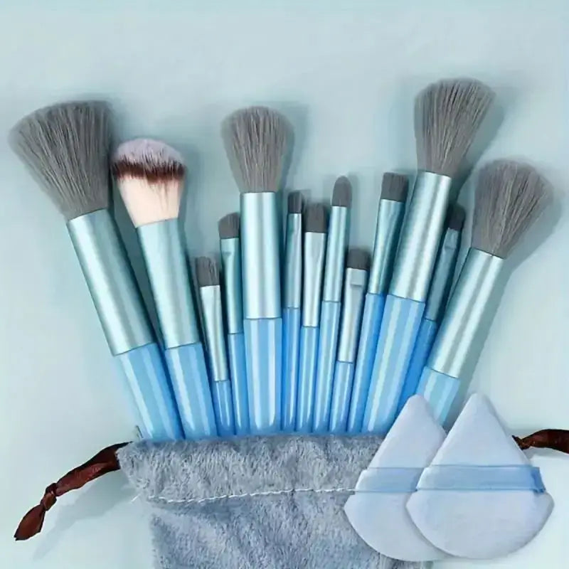 Set of makeup brushes with blue and silver handles in a gray fabric holder.