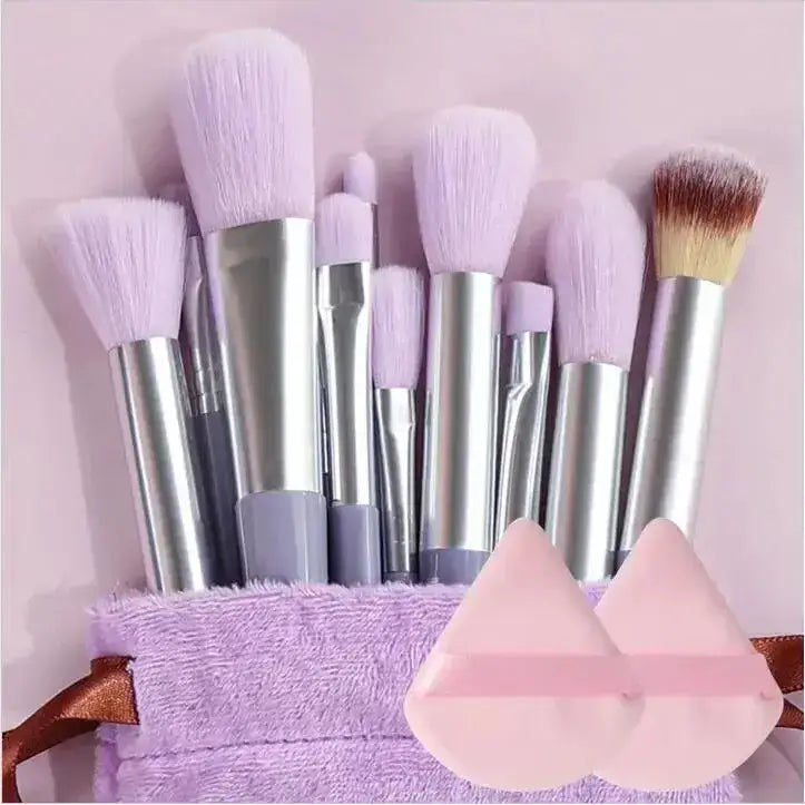 Set of makeup brushes with silver handles and mostly lavender-colored bristles.