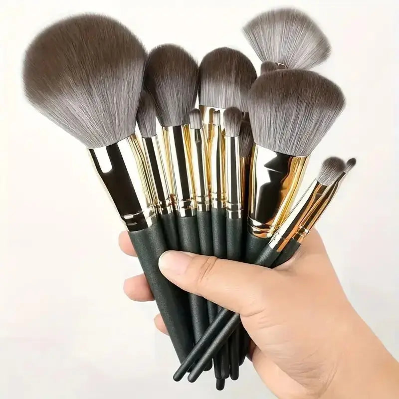 Set of makeup brushes with various sizes and shapes held in a hand.