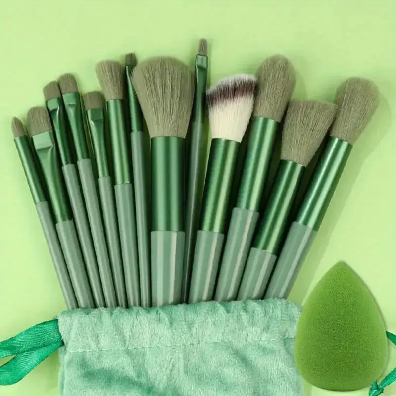 Set of green makeup brushes with a beauty blender sponge.