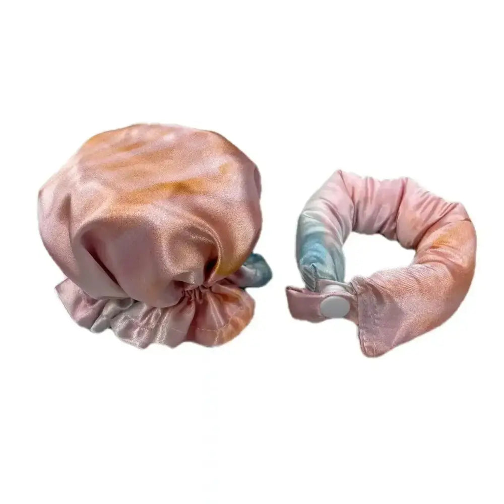 Satin or silk shower cap and matching hair scrunchie in pastel pink and blue colors.