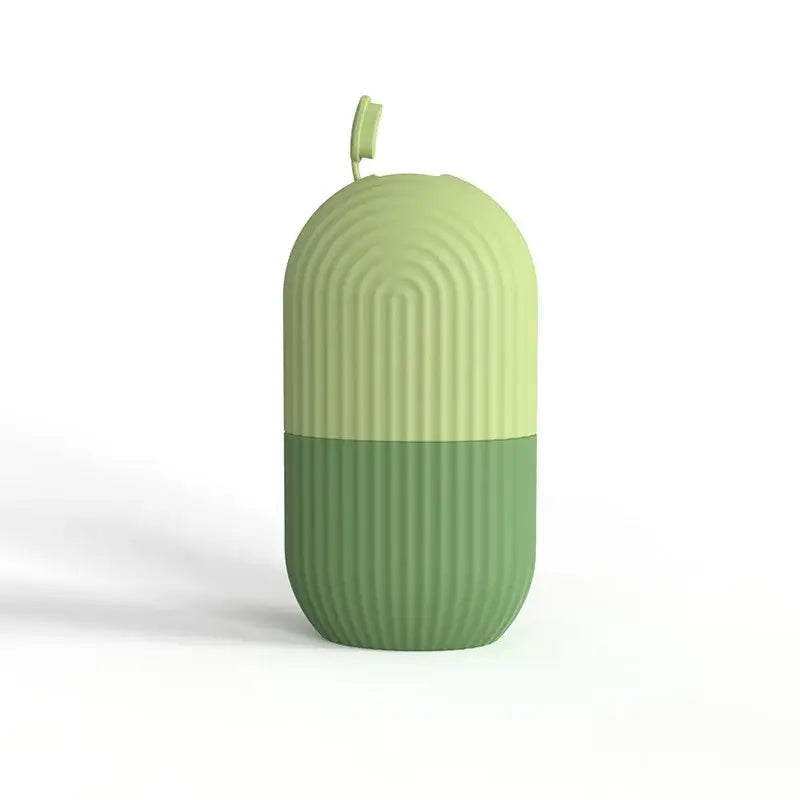 Capsule-shaped green object with ridged texture and a small stem-like protrusion on top.