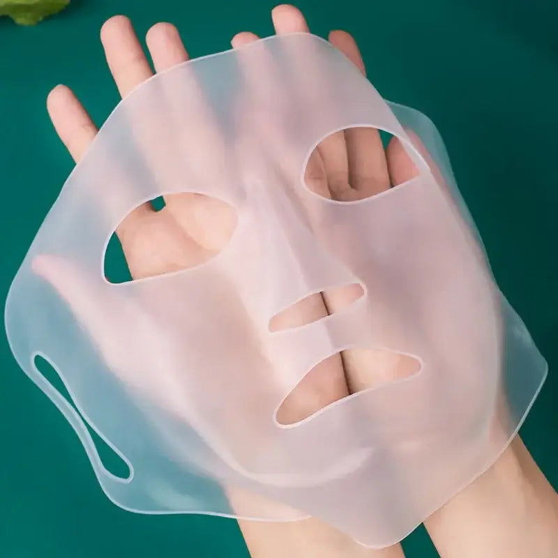 Translucent silicone face mask held by a hand.