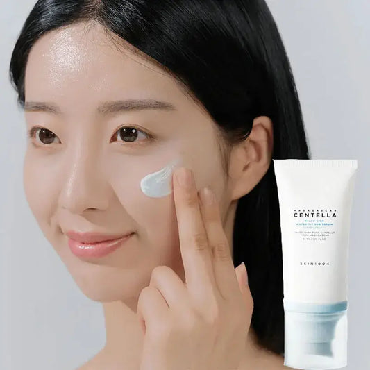 Woman applying skincare cream to her face next to a product tube.