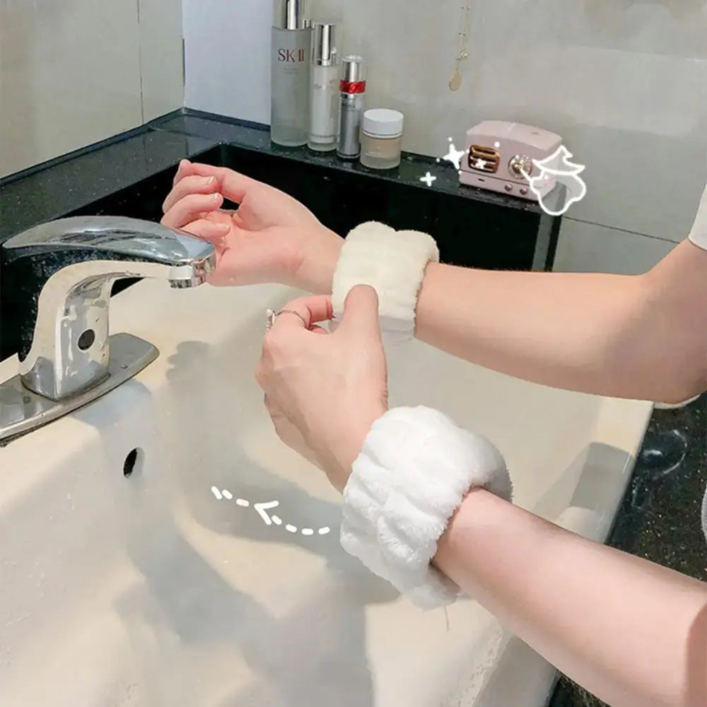 Washcloth being wrung out over a bathroom sink.