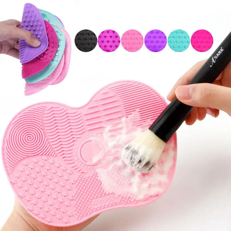 Heart-shaped silicone makeup brush cleaning pad with various textured surfaces.