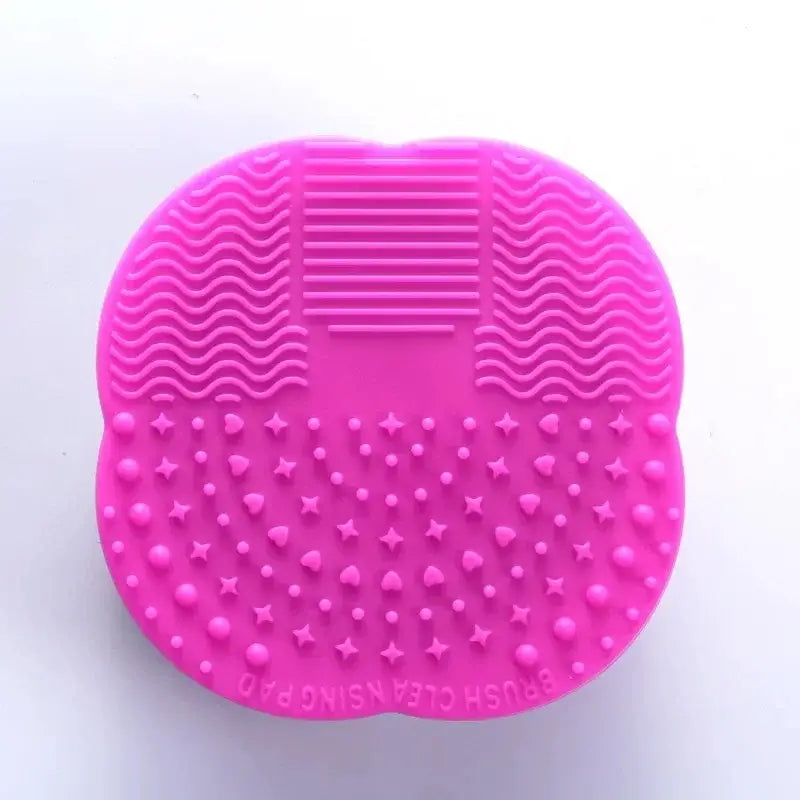 Bright pink silicone makeup brush cleaning pad with textured surfaces.