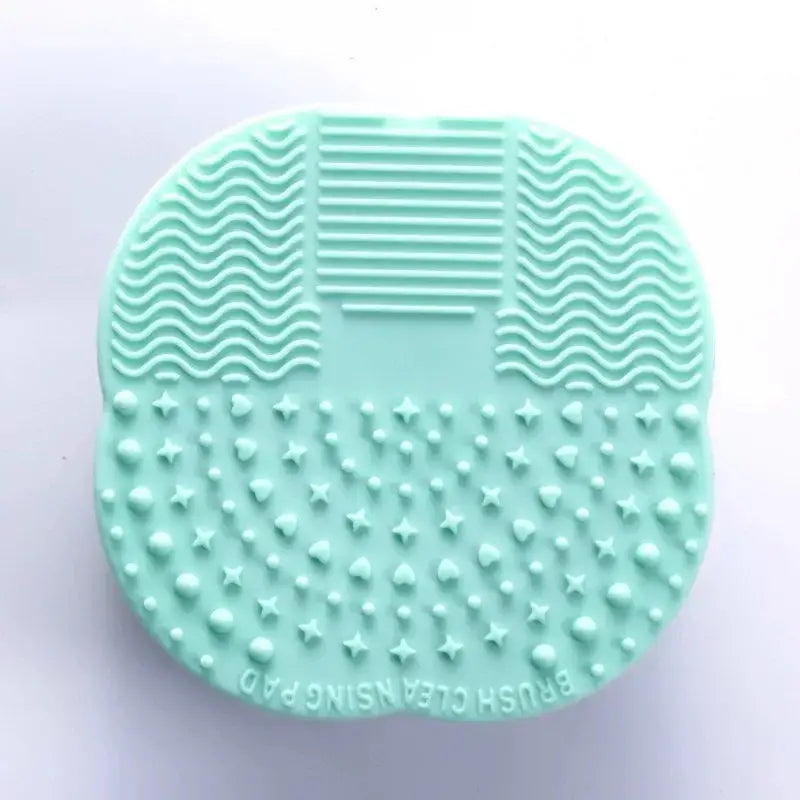 Mint green silicone brush cleaner with various textured surfaces.