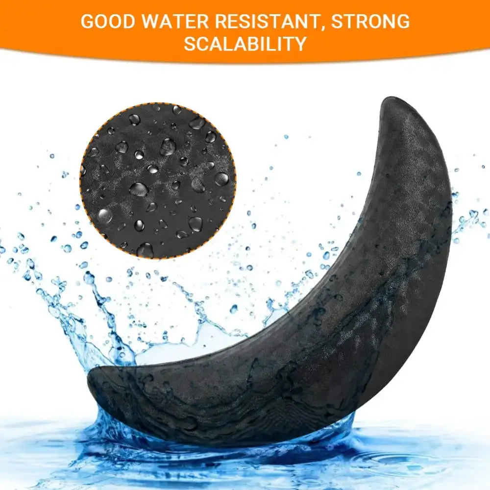 Curved black object resembling a banana shape with a textured surface, surrounded by water splashes.